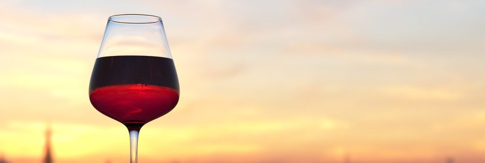 Kieliszek czerwonego wina na tle zachodu słońca